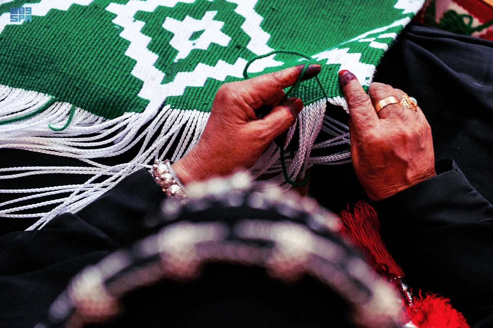 Close-up of an artisan's hands weaving a traditional heritage textile