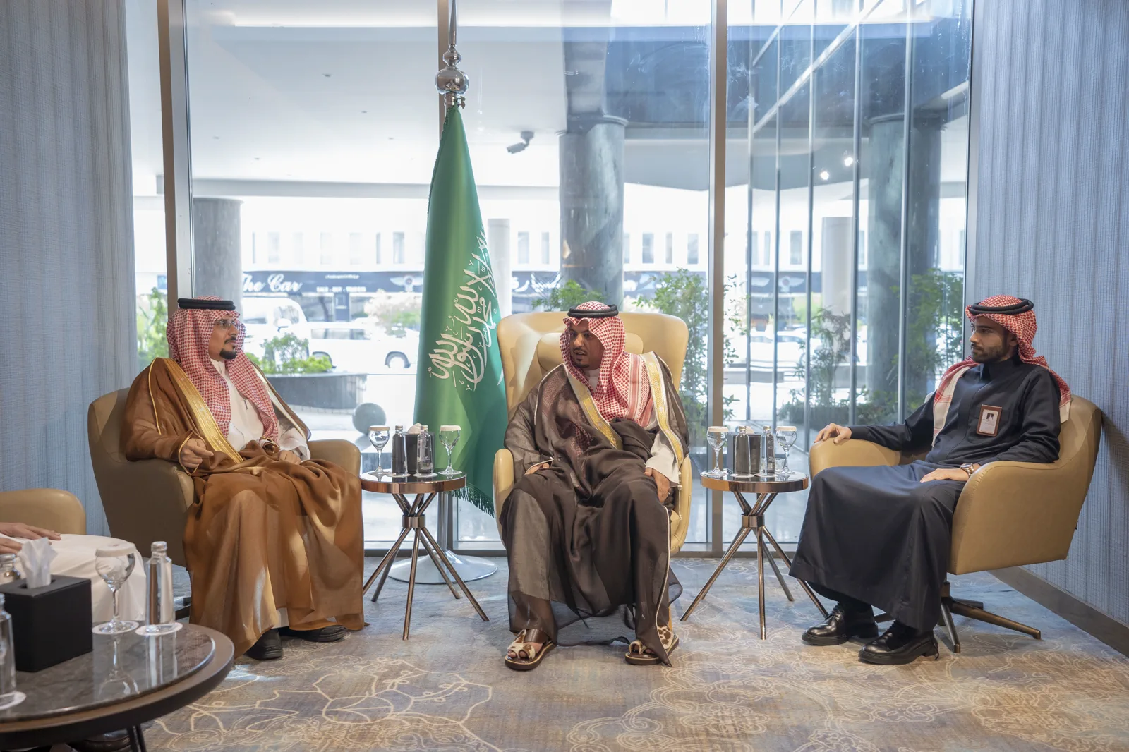 A senior delegation received in a formal, light-filled setting with the Saudi flag