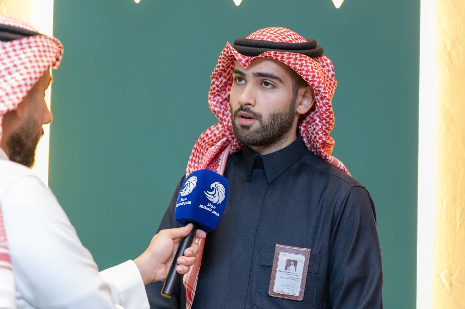 A leader addressing the national press before a teal Mawroth backdrop