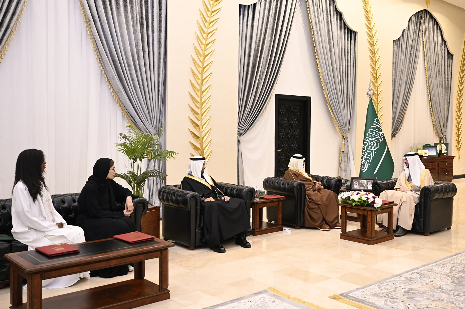 A formal audience seated in a royal majlis diwan