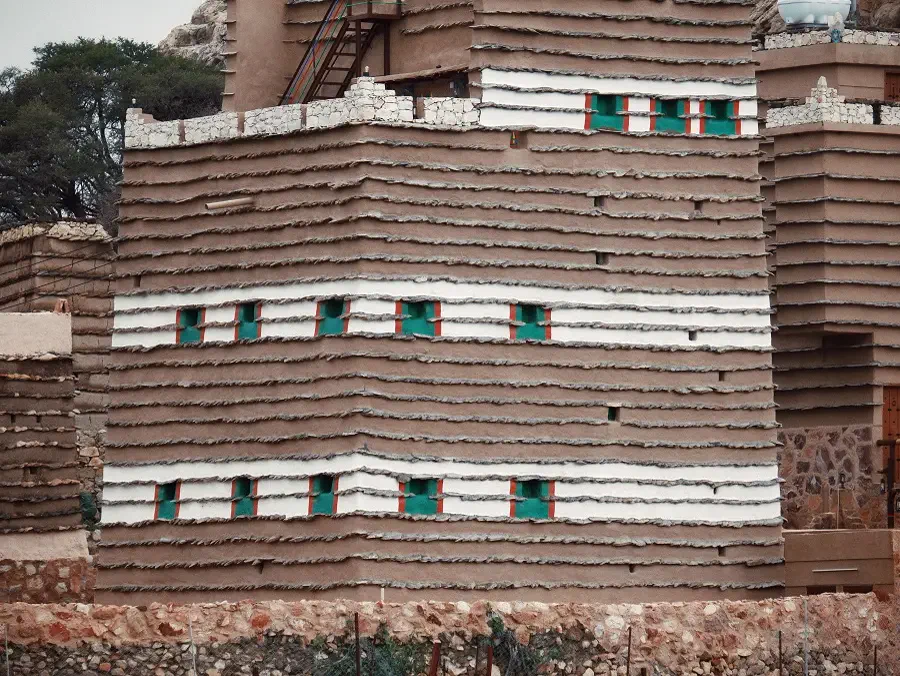 Multi-storey Asiri mud-brick tower with striped trim and green shutters, Rijal Almaa