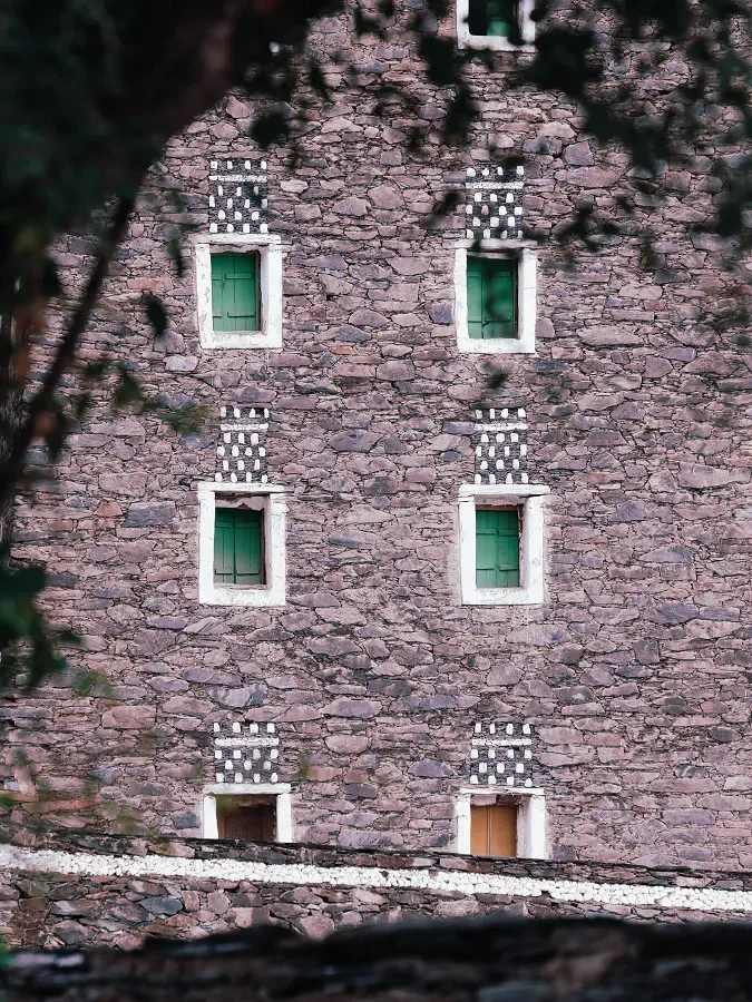 Stone-walled Asiri heritage tower with green shuttered windows, Rijal Almaa