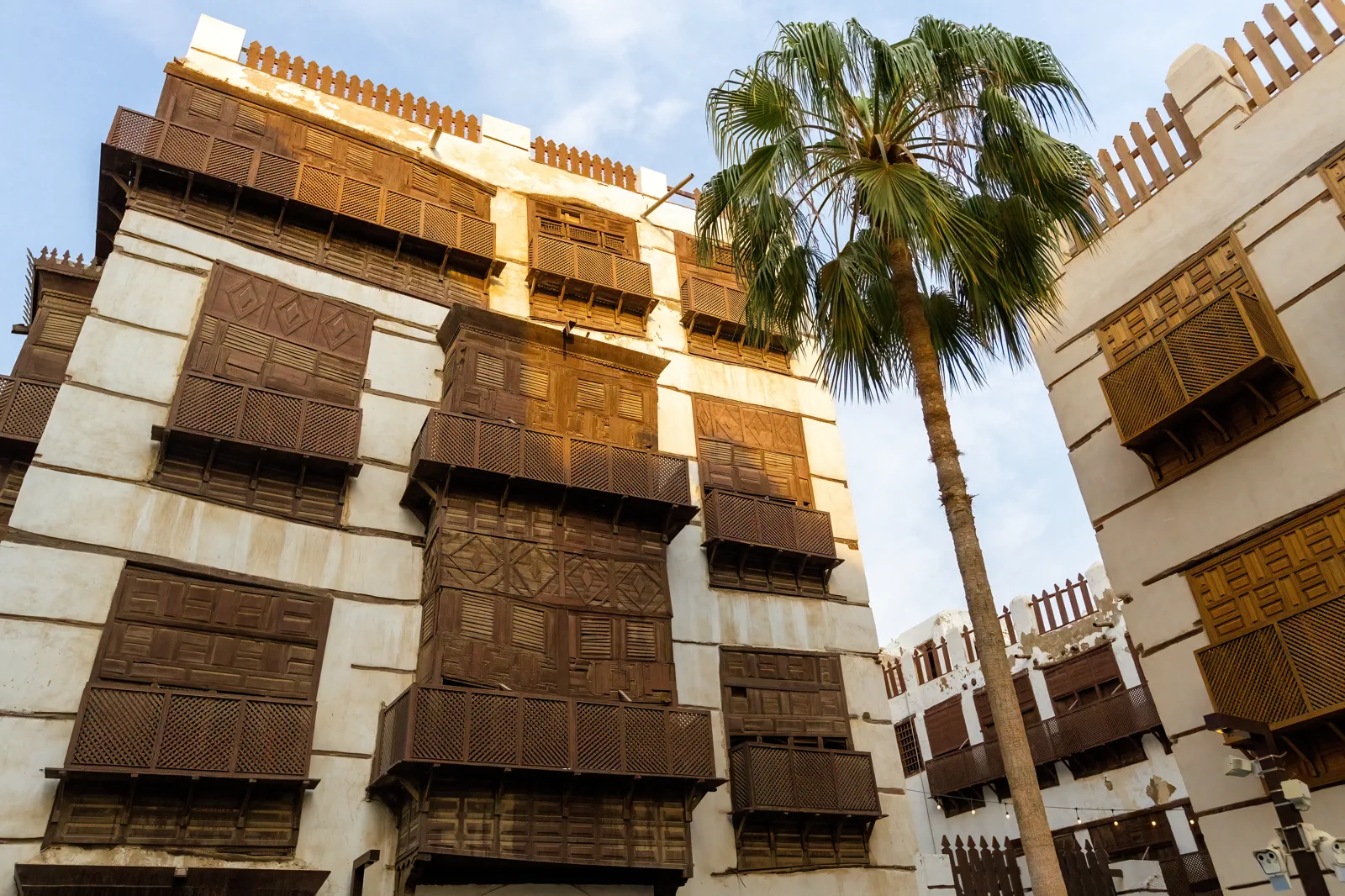 Warm-lit stacked wooden mashrabiya balconies on Al-Balad building, Jeddah